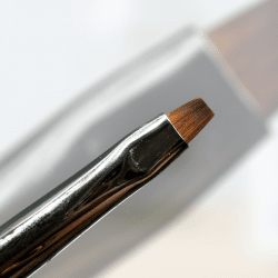 One stroke-pensel med rakt borst, lila metallskaft med snygga detaljer och en matchande lila skyddshylsa för förvaring. Perfekt