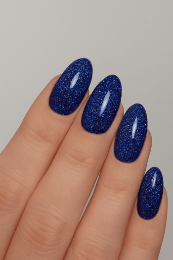 Blue glitter gel polish from Nail Systems that gives the nails a sparkling and elegant look.