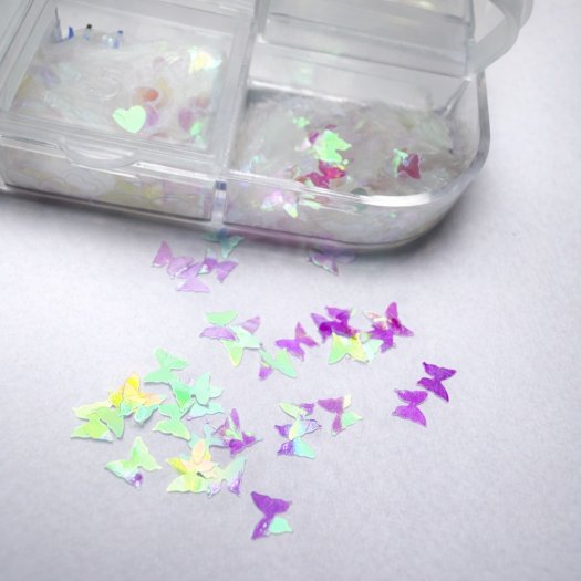 Ask med 12 tunna, transparenta paljetter i mixade former och storlekar. Skiftande finish, enkla att forma mot nageln och perfekt