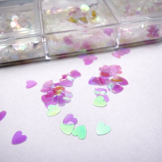 Ask med 12 tunna, transparenta paljetter i mixade former och storlekar. Skiftande finish, enkla att forma mot nageln och perfekt