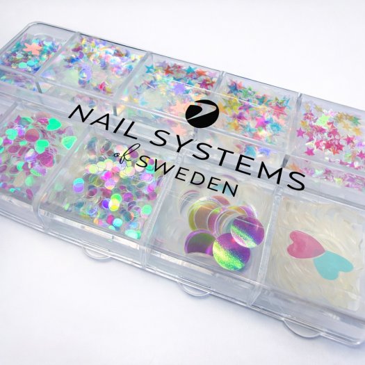 Ask med 12 tunna, transparenta paljetter i mixade former och storlekar. Skiftande finish, enkla att forma mot nageln och perfekt