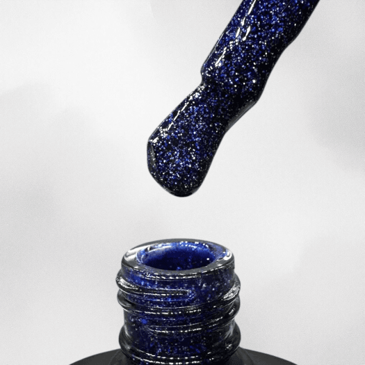 Blue glitter gel polish from Nail Systems that gives the nails a sparkling and elegant look.
