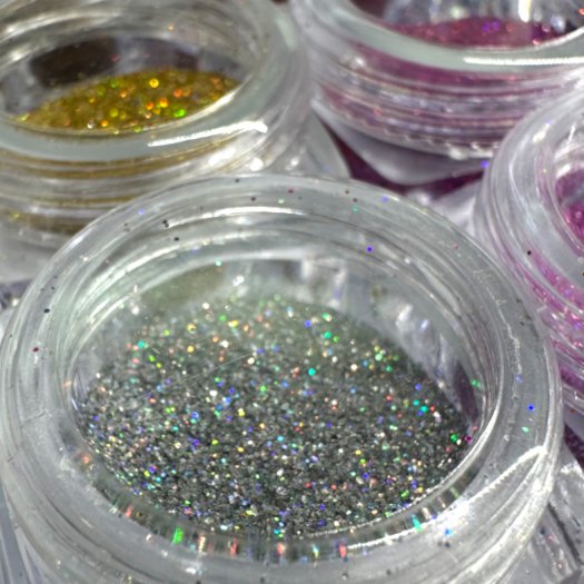 Nagelglitter i 0,2 mm partiklar, holografiskt skimmer i djupa färger. Set med 12 olika nyanser i en praktisk ask.