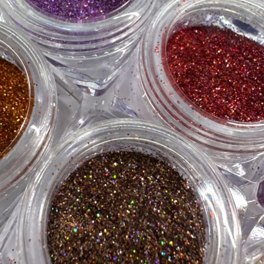 Nagelglitter i 0,2 mm partiklar, holografiskt skimmer i djupa färger. Set med 12 olika nyanser i en praktisk ask.