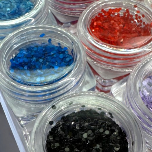 Pärlskimrande paljetter i 1 mm storlek. Set med 12 olika färger för eleganta och kreativa nageldesigner.