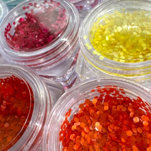 Pärlskimrande paljetter i 1 mm storlek. Set med 12 olika färger för eleganta och kreativa nageldesigner.