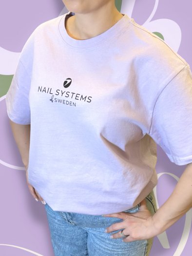 Ljuslila oversized T-shirt i mjukt och tjockt bomullstyg med svart Nail Systems-logga fram och bak. Boxig passform och rund hals