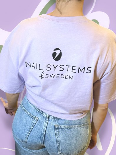 Ljuslila oversized T-shirt i mjukt och tjockt bomullstyg med svart Nail Systems-logga fram och bak. Boxig passform och rund hals