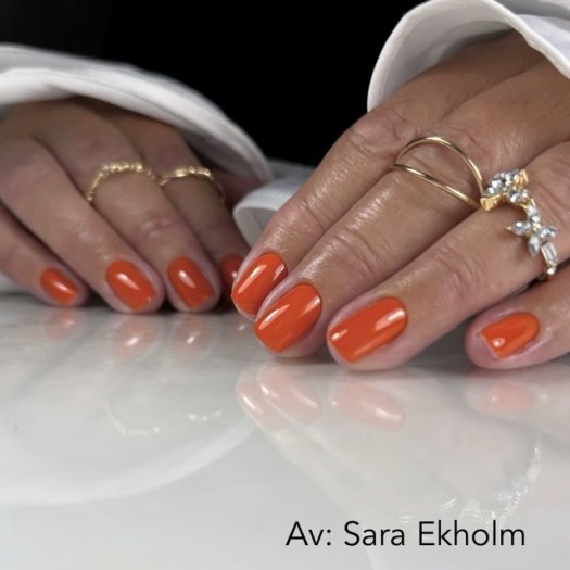 Nemo Gel Polish from Nail Systems in a bright and vibrant orange shade that gives the nails an energetic and playful look.