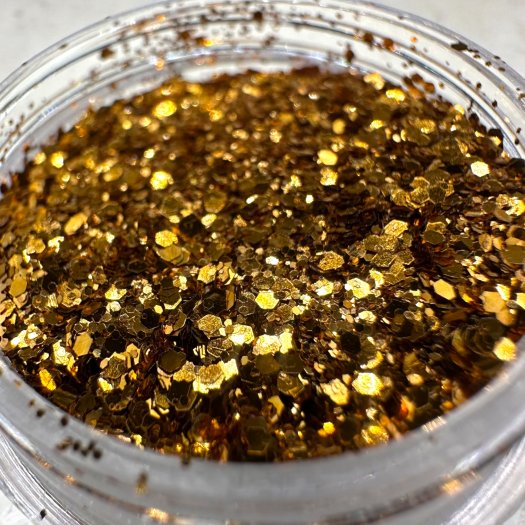 Glit-Mix Amber Bronze är ett varmt bronsfärgat glitter i mixade storlekar med inslag av bärnstensglöd. 5g burk. Används i klibbi